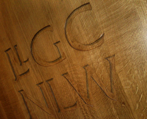 The Drwm Podium Carving on the spotlit podium, inside the Drwm auditorium