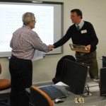 Two men shake hands during training role-play
